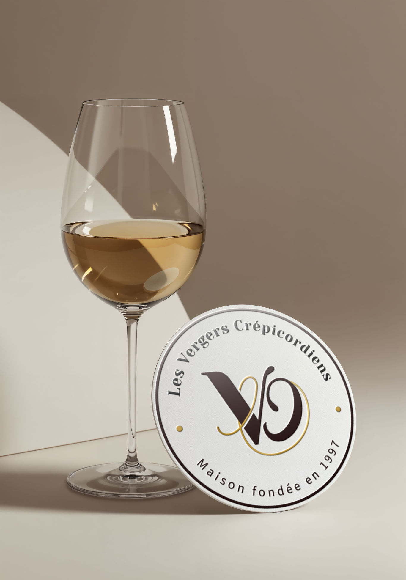 Les Vergers Crépicordiens Verre de vin blanc posé à côté d'un sous-plat décoratif, fond neutre.