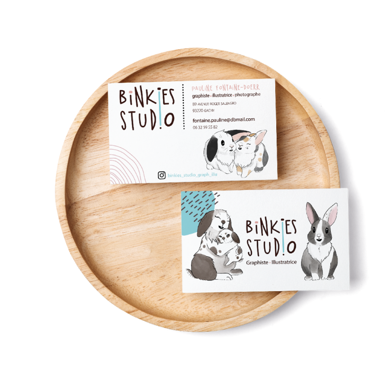 Cartes de visite illustrées avec des lapins, présentées sur un plateau en bois.